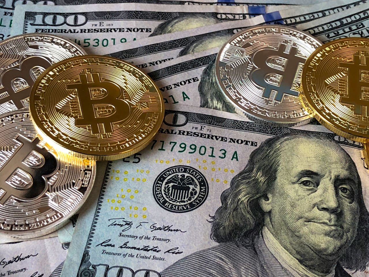 Services-03 A close-up photo depicting Bitcoin coins on top of US dollar bills, symbolizing finance and cryptocurrency.